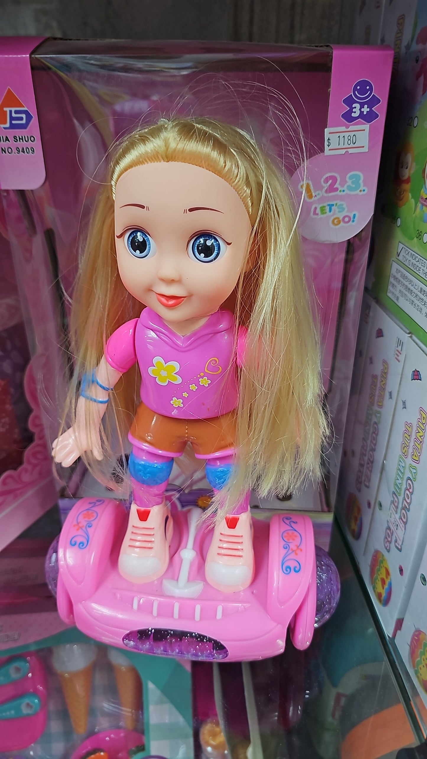 MUÑECA EN PATINETA A PILAS